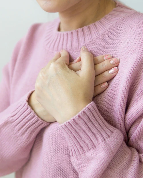 Mujer sosteniendo sus manos en el corazón